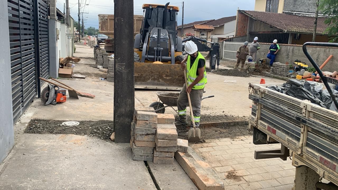 Equipe recompondo calçada e meio-fio após obra de saneamento